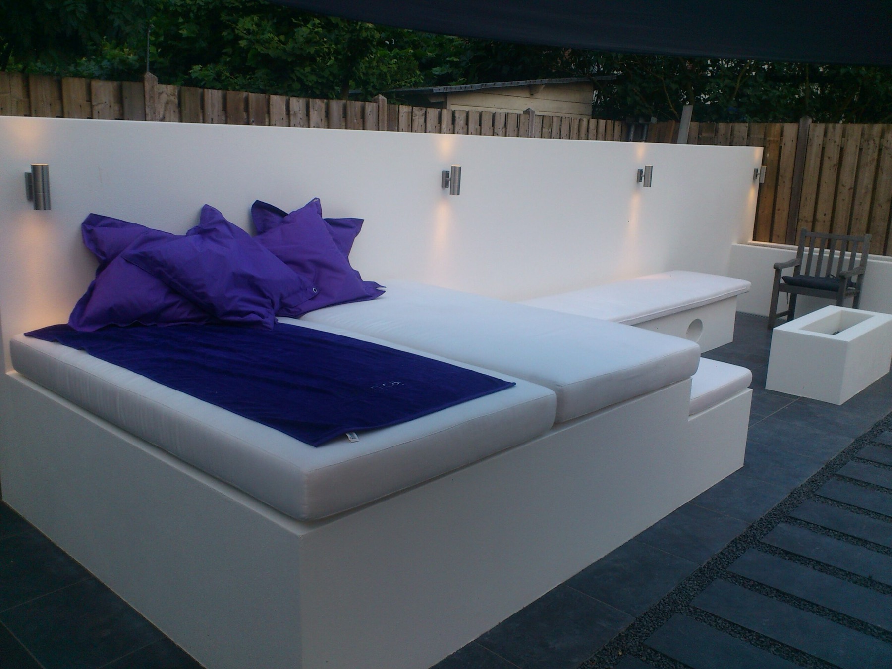 Gemetselde loungebank op terras met verlichting
